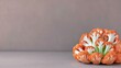 © Athar - A close-up studio shot of an orange cauliflower head on a gray surface. The image is well-lit, highlighting the texture and color of the vegetable.