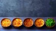 © andiend - Close-up of several quiches with different fillings, including peas, arranged on a wooden table. Food photography with a moody aesthetic.
