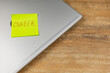 © mykhailo - Sticky note with career reminder on laptop at home office desk