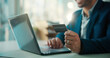 © peopleimages.com - Credit card, hands and laptop with business man at desk in office for portfolio investment. Computer, payment and stock market trading with broker in financial workplace for purchase or transaction