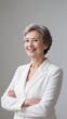 © Yka - Senior caucasian woman in white suit smiling with arms crossed