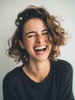 © Tima - Woman with short curly hair laughing loudly with closed eyes. Happy emotion on female caucasian model face. Portrait for concept of joy.