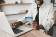 © kite_rin - Man hand holding credit card and using laptop at home, Businessman or entrepreneur working at office, Online shopping, e-commerce, internet banking, spending money, working from home concept
