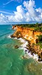 © Ziyan - High angle view of coast with red clay cliffs meeting turquoise ocean under a sky of fluffy clouds
