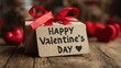 © Jayk - Valentine's Day gift with a red ribbon and a heart-shaped tag on a wooden table