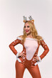 © Granmedia - Smiling woman in a festive doe costume with antler headband and soft fur trim posing confidently against a clean studio background, ideal for holiday designs and seasonal creative content