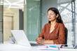 © Liubomir - Young indian businesswoman sitting at her modern office desk with closed eyes, meditating for a calming mental break and practicing mindfulness during a busy workday
