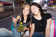© dodotone - Two young woman sisters sitting tuk tuk taxi local tour hanging out trip gen Z hipster travel in Bangkok, Thailand