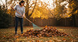 © Tamaras Pictures 4U - Woman raking autumn leaves in garden during sunset