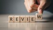 © Yasmin - Hand placing wooden block to complete the word review concept of feedback customer satisfaction and evaluation of a product or service