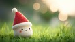 © NingPhattraphorn - A cute, festive character wearing a red Santa hat sits on green grass, surrounded by a soft, blurred background of light, Christmas background with doodles