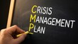 © Stocks Buddy - A chalkboard crisis management plan with highlighted initials and hand writing for business risk assessment and management