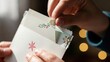 © Raja - Close-up of hands opening a white Christmas card with floral designs on a blurred background with warm lights.