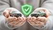 © Andrey_Lobachev - Insurance agent holds one intact toy car and one damaged toy car in front of an insurance-related symbol, illustrating risk and protection concepts.