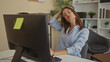 © Krakenimages.com - Woman in glasses sits at office desk in front of computer monitor and stretches neck in building; relief.