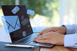 © New Africa - Email notification. Man using laptop at table, closeup. Letters flying out of screen