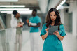 © Zamrznuti tonovi - Medical professional using digital tablet in hospital corridor