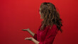 © Krakenimages.com - Smiling young woman in red blouse and glasses presents with outstretched hands against a vibrant red background, conveying joy and enthusiasm in an isolated setting.