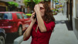 © Krakenimages.com - Woman talking on smartphone outdoors in vibrant city street showcasing lively urban interaction with blurred red car background conveying dynamic communication presence.