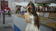 © Krakenimages.com - Teenage girl with long hair and glasses pressing her forehead with one hand at a street market stall displaying jewelry trays and tents; frustration.