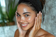 © JulieMeneghin - Portrait de beauté rapproché d'une femme joyeuse et souriante appliquant un sérum ou un soin hydratant sur son visage, routine de soins de la peau, traitement de luxe, peau nette et brillante