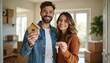 © Vadym - Happy young couple hold house keys and model home inside their new apartment. Boxes indicate moving day is here. They celebrate first home purchase as happy homeowners.