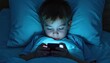 © Vadym - Young boy in bed uses mobile phone late at night. Bright blue light from screen illuminates face. Child focuses on smartphone in dark room. Kid plays game watches video. Digital screen media impacts
