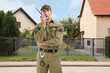 © New Africa - Security guard in uniform using radio near house outdoors. Private property protection