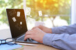 © New Africa - Email notification. Man using laptop at table, closeup. Letters flying out of screen