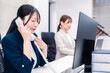 © maroke - オフィスでお詫びの電話をする若いキャリアウーマン