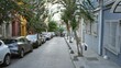 © Krakenimages.com - Narrow residential lane lined with parked cars and flowering trees, softly defocused bokeh street; background, copyspace, backplate.