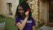 © Krakenimages.com - Woman volunteer holding heart paper on street outdoor in old town, smiling in purple shirt, showcasing hispanic culture.