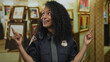© Krakenimages.com - Smiling woman police officer points finger to colorful abstract painting in gallery; appreciation curiosity.