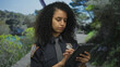 © Krakenimages.com - Woman police officer using tablet in outdoor park setting showcasing focus and professionalism
