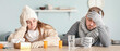 © Pixel-Shot - Sick couple sitting at kitchen table