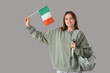 © Pixel-Shot - Female student with flag of Ireland on grey background