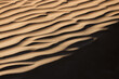 © Travel 'n' Lifestyle - View of undulating sand dunes, painted in warm hues and stark shadows, carve a mesmerizing pattern across the desert landscape, Rub' al-Khali, United Arab Emirates.