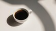 © mbah - Aesthetic White Cup of Black Coffee with Natural Light Shadows.