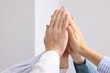 © New Africa - People holding hands together indoors, closeup. Team building