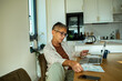 © Marko Geber - Mature adult man paying bills online at home kitchen, focused