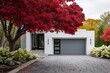 © gamespirit - Modern house with gray garage door and bright red trees in autumn setting located in a residential neighborhood during the fall season