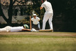 © Jacob Lund - Cricket player diving to make the crease as umpire observes play
