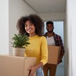 © Andrii Zastrozhnov - African young adults moving with boxes and plant in hallway