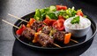© Terrance - grilled beef skewers with rice and fresh vegetable salad on black plate