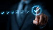 © rashedhossain - Person in dark suit selects glowing checkmark on digital interface dark blue