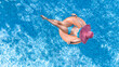 © Iuliia Sokolovska - Aerial drone view of beautiful woman in hat relaxing in swimming pool, young girl in bikini swims on inflatable ring donut and has fun in blue pool water, tropical vacation on holiday resort