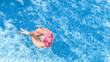 © Iuliia Sokolovska - Aerial drone view of beautiful woman in hat relaxing in swimming pool, young girl in bikini swims on inflatable ring donut and has fun in blue pool water, tropical vacation on holiday resort