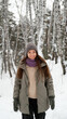 © ekaterinabyuksel - A beautiful young woman in winter clothes is happily spending her free time in a snowy forest. She enjoys the first snow. Active winter recreation.