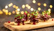 © Silvia Bogdanski - Kleine Rinderbraten-Canapés liegen auf einem Holzbrett und sind mit Cranberry-Glasur sowie frischen Microgreens dekoriert