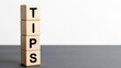 © arsyi_06 - Wooden blocks spelling 'TIPS' stacked vertically on a dark surface, white background